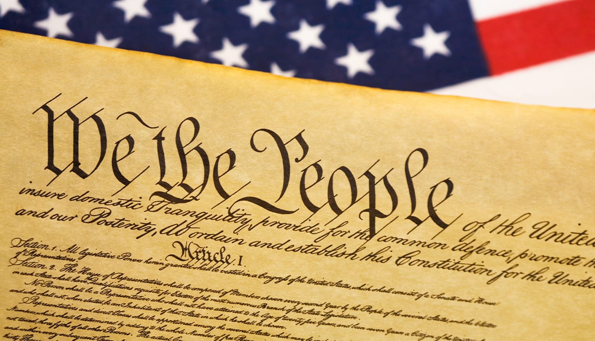 The constitution with the American flag in the background